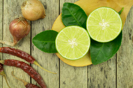 lime slice, onions and dried chilli on wood plank backgroundの写真素材