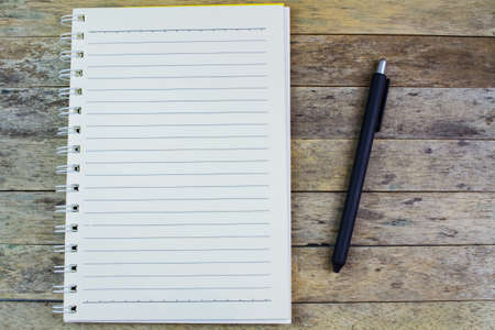 notebook and pen on a wood tableの写真素材