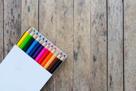 color pencils in a box on wood plank backgroundの写真素材