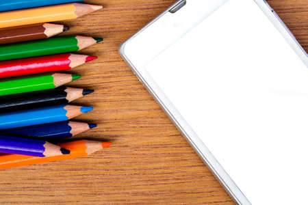 pencils color and smart phone on wood background, top viewの写真素材