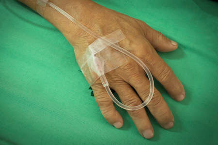 old man hand is receiving patient intravenous saline, vignette corner