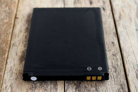 battery of smart phone on wood background, soft focusedの写真素材