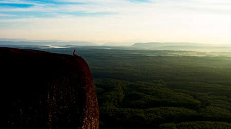 The man is sitting on top of the mountainの写真素材