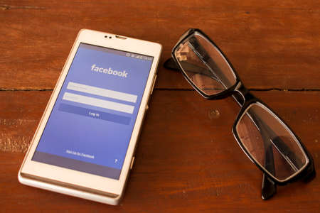BUNG KAN, THAILAND - JANUARY 10, 2016: smart phone display facebook app on office desk