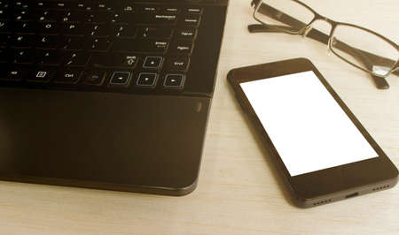 smart phone and notebook and glasses on desk with sunlight color