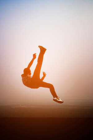 silhouette man jumping kick on top of the mountain, with sunlightのeditorial素材