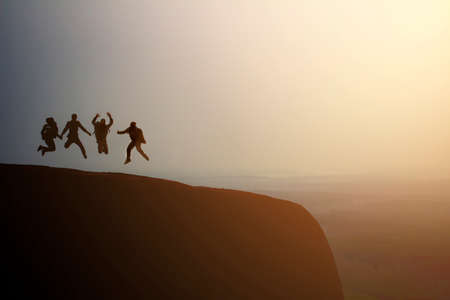 silhouette group of young jumping on the top of the mountain, copy spaceの写真素材