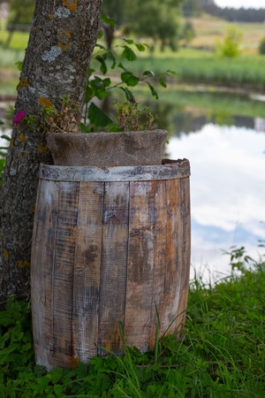 Wooden old gray barrel on the nature near the lakeの写真素材