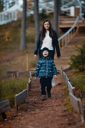 boy with mother on a walk in a pine forestの写真素材