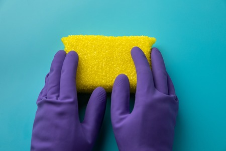 cleaning on blue background. two hands holding a sponge for washing. Flat lay, Top view.の素材 [FY310111948493]