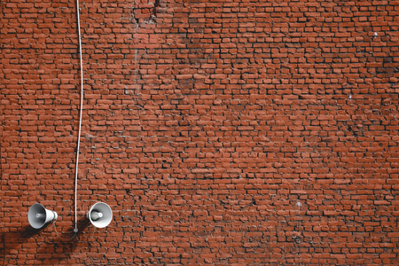 white loudspeakers on a red brick wall backgroundの写真素材