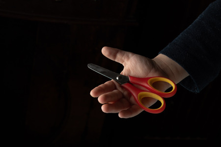 baby with scissors. Mylys holds scissors on a black backgroundの写真素材