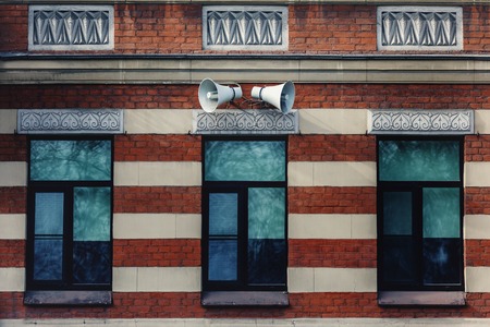 Siren loudspeakers on the wall of a house in the cityの写真素材