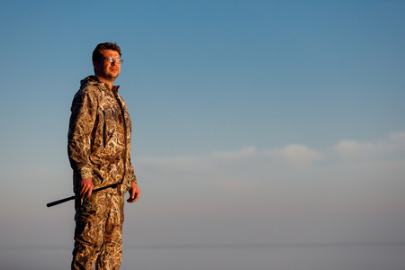 Man catches fish standing on stones in waterの写真素材