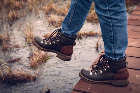 step into the swamp. boots against the water.