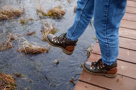 step into the swamp. boots against the water.