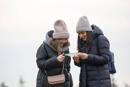 two girls walk in nature and look at the ice
