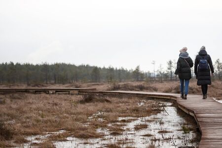 two girls walk in nature and look at the ice