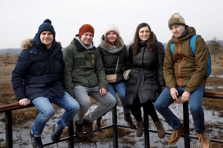 5 people in nature walk and take photos of selfies