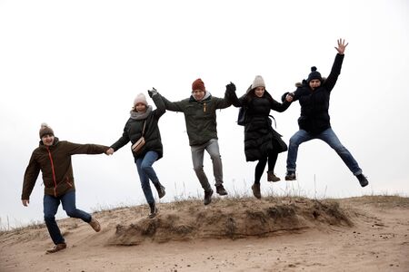 Five people jump. company of friends relaxes in natureの写真素材