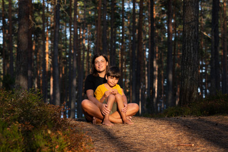 mother and son hug. Evening sun in a pine forest.