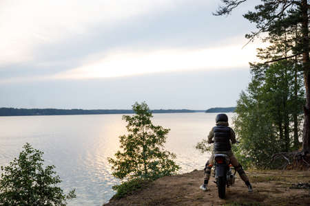silhouette of a girl on a motorcycle at sunsetの写真素材