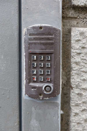 old intercom at the entrance to a residential building