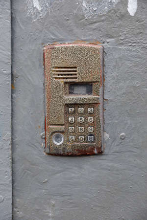 old intercom at the entrance to a residential building