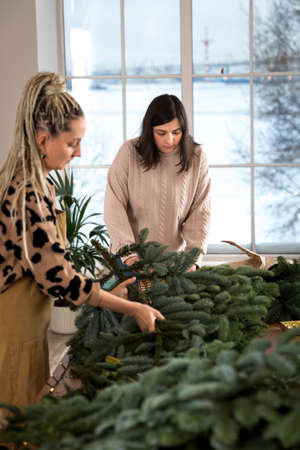 DIY Christmas composition from nobilis. Wreath decor for holiday decorations. Girls at a workshop on...