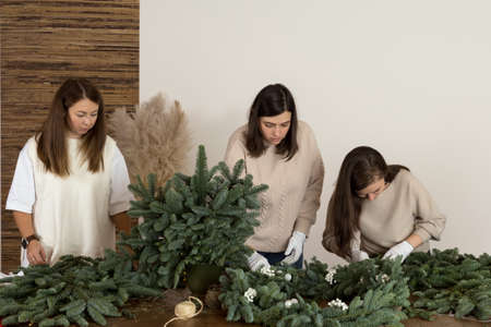 DIY Christmas composition from nobilis. Wreath decor for holiday decorations. Girls at a workshop on...