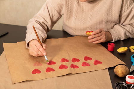 heart shaped potato stamp on craft paper. The process of decorating a gift for Valentines Day. Getting ready for the celebration on February 14th.の写真素材