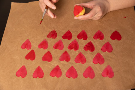 heart shaped potato stamp on craft paper. The process of decorating a gift for Valentines Day....