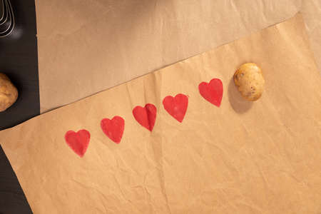 heart shaped potato stamp on craft paper. The process of decorating a gift for Valentines Day....