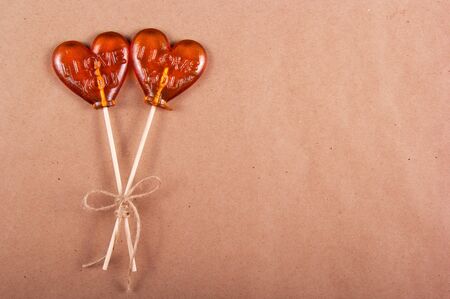 Two lollipop in the shape of a heart on a paper background. Copy spaceの写真素材