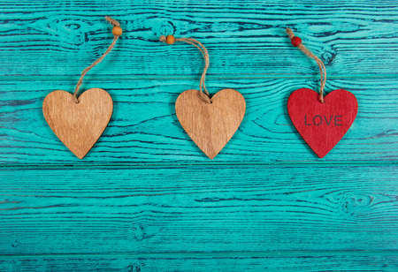 Wooden hearts on a blue background. Pendants made of wood in the form of heart. Copy space. Top viewの写真素材
