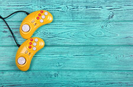 Video game console GamePad on a old blue wooden background table. Yellow retro GamePad. Copy space.