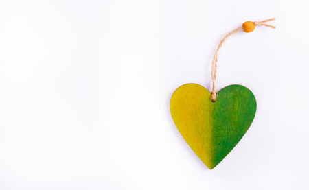 Red wooden pendant in the shape of heart. Wooden heart on a white background. Copy space.の写真素材