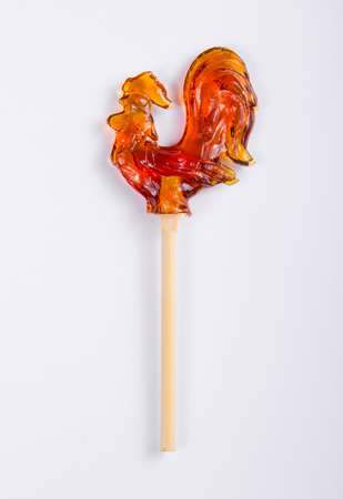 Cock on a stick on a white background. Russian candies. Lollipop in the shape of a cockerel.の写真素材
