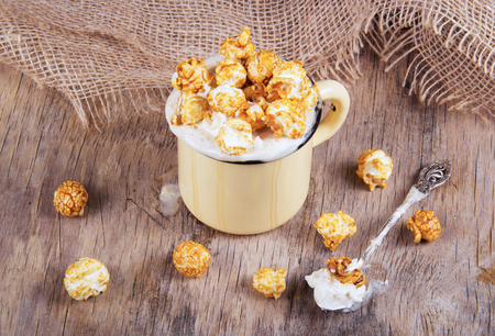 Coffee and caramel popcorn in an iron old mugの写真素材