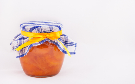 A jar of apricot jam on a white background. Copy spaceの写真素材