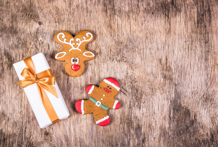 Gift box, gingerbread man and gingerbread. Festive background. Wooden textureの写真素材