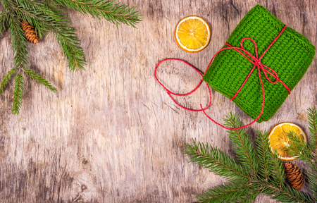 Christmas decoration with a fir tree, chic, gift.  Knitted gift. Packing of gift. Wooden Christmas background.の写真素材