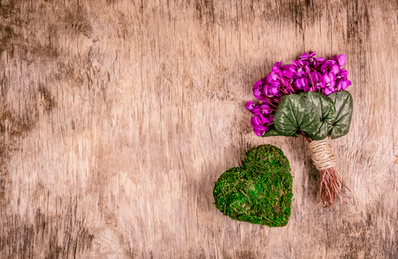 Spring flowers and heart from moss. Romantic bouquet with heart. Delicate violets and heart. Copy space.の写真素材