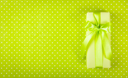 Gift box on light green background. Box with surprise on  polka dot background. International Women's Day. Copy space. Top viewの写真素材