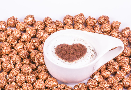 Cup of cappuccino and caramelized popcorn. Romantic concept. Cappuccino with heart.の写真素材