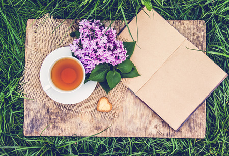 Fresh spring flowers and cup of tea. An open book with blank pages and  flower. Romantic concept.の写真素材
