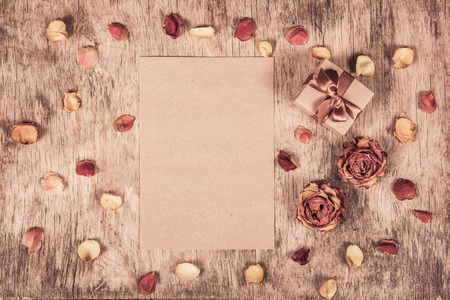 Gift box, letter and roses on wooden background.  Dried roses.の写真素材