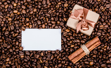 Gift box with bow and anote. Message and gift box on coffee background. Copy space. Scrapbook. Top viewの写真素材