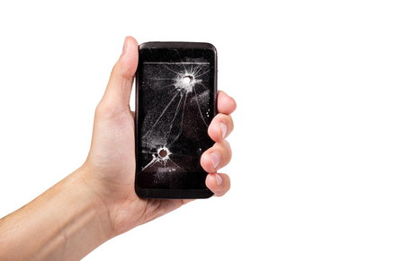 Male hand is holding a broken mobile phone. Smart phone with bullet hole. Copy spaceの写真素材