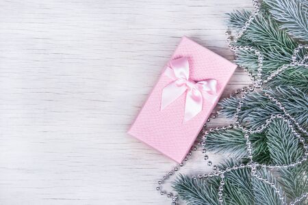 Fir branches and gift on white background. Beautiful pink box copy space. Christmas and New Year conceptの写真素材